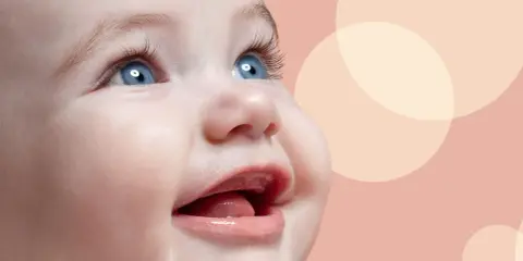 Uśmiechnięta buzia niemowlaka, jak widzi 3 miesięczne dziecko, z niebieskimi oczami i otwartymi ustami, na tle pastelowych kół.