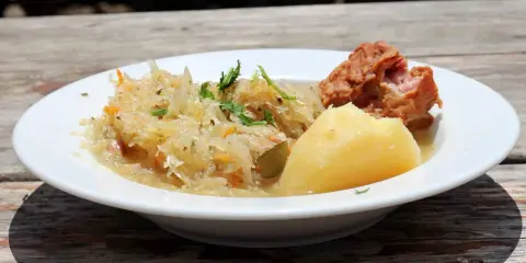 Danie z restauracji Bacówka: ziemniaki, kapusta kiszona z marchewką i kawałek mięsa. Pyszne, tradycyjne danie z menu.