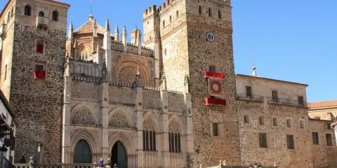 Impresionante catedral en Cáceres, con niños disfrutando de la plaza.