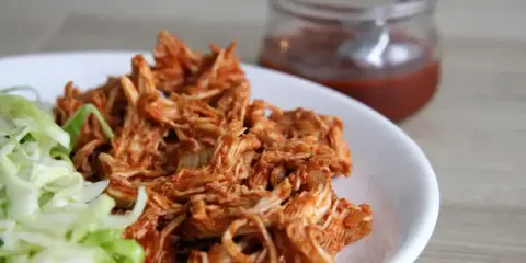 Pyszny, soczysty szarpany kurczak w sosie barbecue, podany z chrupiącą sałatą. Idealny na szybki obiad.