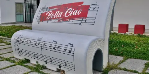 Ławka w kształcie książki z nutami i napisem "Bella Ciao". To symbol wolności i oporu, który znaczy "żegnaj piękna".