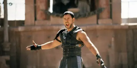 Maximus, gladiator, krzyczy w amfiteatrze, gotowy do walki. Kto to?
