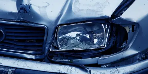 Uszkodzony przód samochodu po wypadku. Zniszczony reflektor i maska. Warto pomyśleć o ochronie zniżek AC.