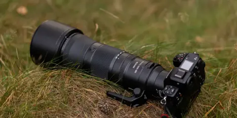 Profesjonalny aparat Nikon Z8 z obiektywem Nikkor 180-600mm leży na trawie. To co to jest aparat, to narzędzie do uwieczniania chwil.