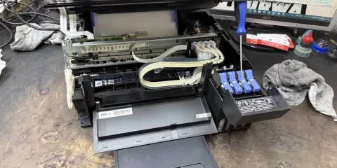 Epson czyszczenie głowicy automatyczne. Widać wnętrze drukarki, tusze i śrubokręt.