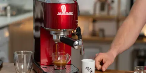Rote Kaffeemaschine brüht Espresso mit Crema. Eine normale Kaffeemaschine für den perfekten Start in den Tag.