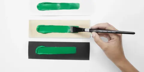 Grüne Acrylfarben-Streifen auf weißem, Holz- und schwarzem Untergrund. Perfekt für den Modellbau, um die Deckkraft zu testen.