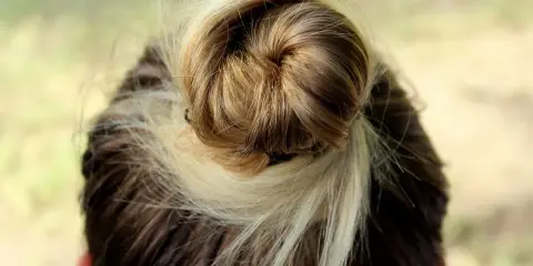 Szybkie i łatwe fryzury do zrobienia samemu: luźny kok z pasemek blond i brązowych włosów.