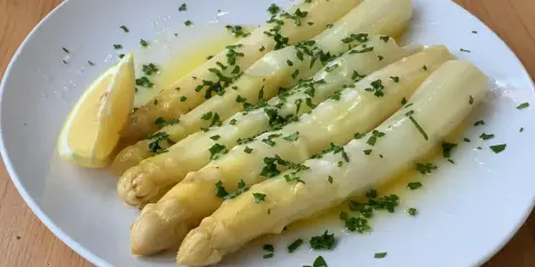 Vitt sparris med smält smör, persilja och en citronklyfta. Perfekt sparris koktid för en lätt och god rätt.