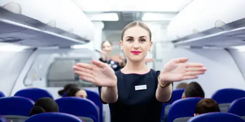 Uśmiechnięta stewardessa Wizzair wita pasażerów. Czy trzeba drukować kartę pokładową Wizzair? Sprawdź przed podróżą!