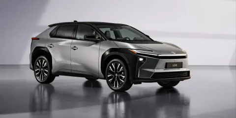 Un elegante SUV plateado con techo negro, uno de los coches eléctricos grandes más modernos.