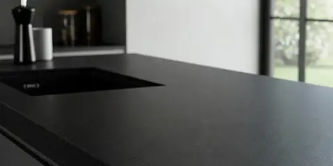 Ciemny, lśniący blat kuchenny z wycięciem na zlew. Dowiedz się, czym czyścić blaty kuchenne, by zachować ich piękny wygląd.