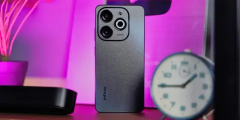 Szary smartfon Infinix z potrójnym aparatem na tle różowego światła. Czy to Infinix co to za firma?