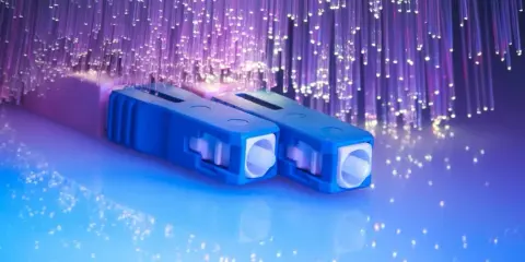 Connecteurs bleus pour télécommunication fibre optique, entourés de fils lumineux violets.