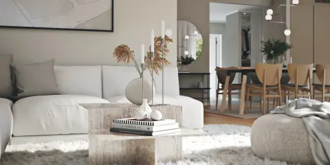 En modern lounge med en vit soffa, ett soffbord i sten och en fluffig matta. I bakgrunden syns en matsal med trästolar, vilket visar olika inredningsstilar.