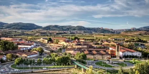Vista aérea de un pueblo con tejados rojos y montañas al fondo. Se ve la bodega RODA, un buen lugar para añada 2017 rioja.