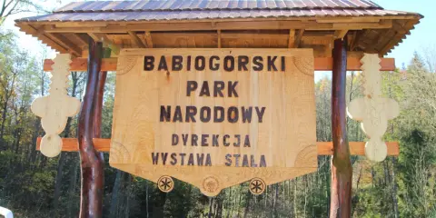 Drewniana brama z napisem "Babiogórski Park Narodowy" zaprasza do odkrywania **zawoja atrakcje**.