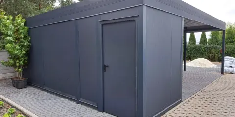 Nowoczesny garaż z wiatą, idealny na działkę bez pozwolenia. Elegancki, ciemnoszary, z praktycznymi drzwiami i zadaszeniem.