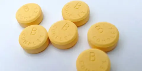 Kilka tabletek z napisem "B COMPLEX". Witamina B complex na co pomaga? Wspiera układ nerwowy i metabolizm.