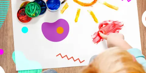 Bambino dipinge un sole con le dita, circondato da vasetti di colori. Un esempio di giochi popolari per bambini che stimolano la creatività.
