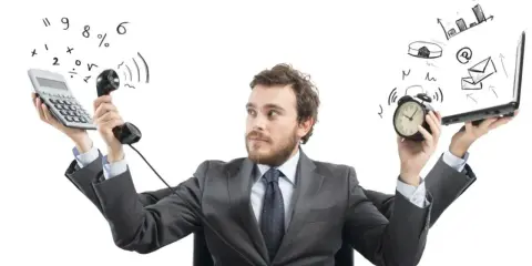 Biznesmen z kalkulatorem, telefonem, budzikiem i laptopem, wygląda na wykończonego, jakby był chorzy ze stresu.