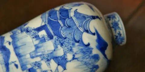 Vase en porcelaine bleue et blanche orné d'une scène complexe, portant un sceau porcelaine signature chinoise.