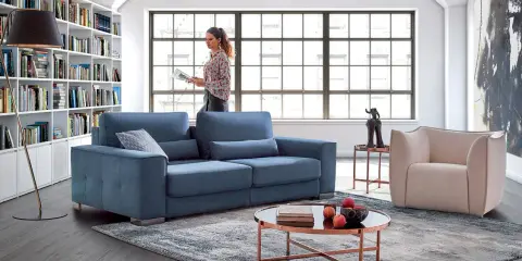 Salon moderne avec canapé bleu, fauteuil beige et bibliothèque. Quelle couleur de canapé choisir pour un style contemporain ?