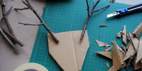 Bastelideen: Pappmache selber machen mit Zweigen und Karton. Ein Basteltisch mit Werkzeug und Materialien für kreative Projekte.