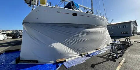 Bateau bâché, prêt pour le sablage de sa coque. Le prix du sablage coque bateau est une étape clé pour sa rénovation.