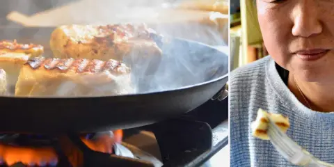Halloumi steks i panna på spisen, ånga stiger. En kvinna njuter av en bit grillost på en gaffel. Ett enkelt grillost recept.