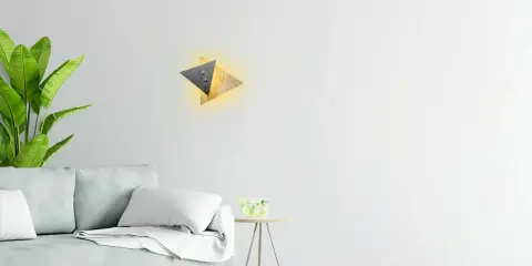 Nowoczesny kinkiet geometryczny z drewnianymi i metalowymi elementami, tworzący ciepłe światło.