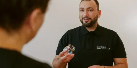 Terapeuta pokazuje bańkę, wyjaśniając, gdzie stawiać bańki na kaszel.