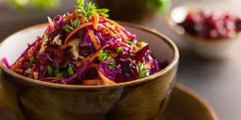 Wykwintna surówka z czerwonej kapusty jak w restauracji, z marchewką, orzechami i żurawiną, udekorowana natką pietruszki.
