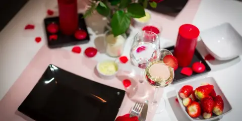 Romantyczna kolacja walentynkowa: czerwone róże, świece, wino i truskawki. Idealne inspiracje, co ugotować na walentynki.