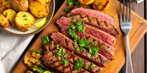 Saftig flankstek, perfekt grillad och skivad, serveras med klyftpotatis och grillade grönsaker. Ett fantastiskt flankstek recept för en härlig middag.