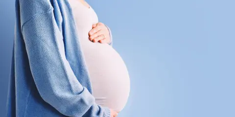 Pancia di donna incinta, con mani che la accarezzano. Si percepiscono le contrazioni di Braxton Hicks, un dolce preludio.