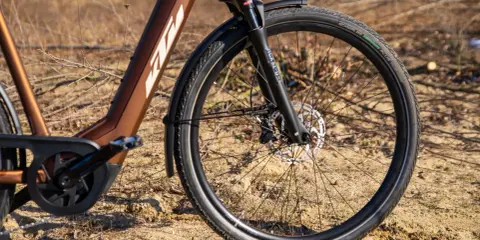 Vorderreifen und Federgabel eines braunen KTM Macina Style E-Bikes. Der Unterschied zwischen dem KTM Macina Style 720 und 730 liegt in den Details.