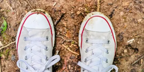 Brudne białe trampki na ziemi. Czas dowiedzieć się, jak wyczyścić białe podeszwy, by znów lśniły!