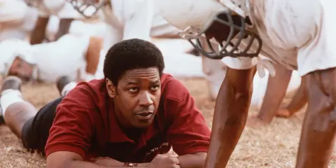 Denzel Washington, allenatore in un film sportivo, ispira la sua squadra. Storie vere di trionfo e determinazione.