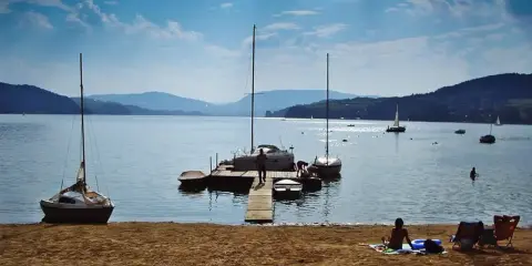 Gródek nad Dunajcem atrakcje: żaglówki przy pomoście, plaża i góry w tle. Idealne miejsce na letni wypoczynek.