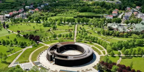Widok z lotu ptaka na park i tężnię solankową w Busku-Zdroju. W oddali widać zabudowania i zielone wzgórza. Sanatoria w Busku-Zdroju oferują relaks i zdrowie.