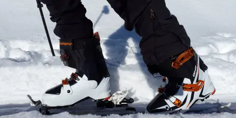 Skitury co to? Widok z perspektywy narciarza w butach i nartach skiturowych, gotowego do podboju ośnieżonych szlaków.