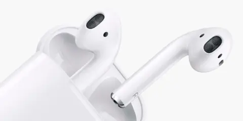 Białe słuchawki AirPods w etui. Dowiedz się, jak sprawdzić ile AirPods mają baterii, by zawsze cieszyć się muzyką.