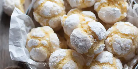 Biscotti al limone morbidi, spolverati di zucchero a velo, invitano a un morso goloso.
