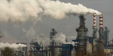 Rauchschwaden steigen aus einer Industrieanlage auf, die die Energieproduktion in China symbolisiert.
