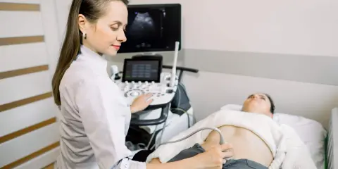 Lekarka wykonuje przygotowanie do usg układu moczowego pacjentki. Na ekranie widoczny obraz z sondy.