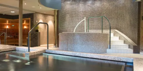 Avslappnande poolområde med bastu och trappa ner till vattnet på Lindvallen Skilodge.