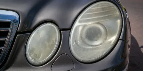 Zmatowiałe lampy samochodu, które wymagają polerowania. Zastanawiasz się, ile kosztuje polerowanie lamp?