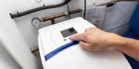Main d'une personne appuyant sur le bouton "SET" d'un adoucisseur d'eau. Le manomètre indique la pression. Le 16 c'est quoi ?