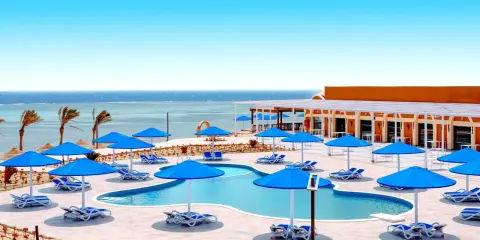 Basen z niebieskimi parasolami i leżakami, widok na morze. Idealne miejsce na wakacje, jak w Pickalbatros Portofino Marsa Alam.